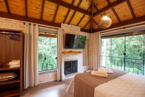 a bedroom with a bed and a fireplace at Vivendas de Monte Verde in Monte Verde