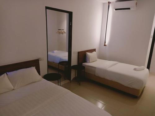 a hotel room with two beds and a mirror at T Hotel Anggerik in Alor Setar