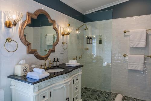 a bathroom with a sink and a shower with a mirror at Wollombi Wines in Wollombi