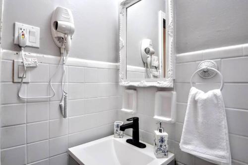 ein weißes Badezimmer mit einem Waschbecken und einem Spiegel in der Unterkunft King Bed! Quiet Pittsburgh Home! Close to City! in Pittsburgh