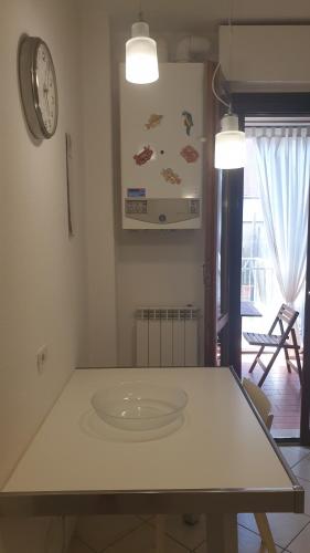 cocina con mesa y reloj en la pared en Casa in affitto a Marina di Grosseto a soli 150 metri dal mare, en Marina di Grosseto