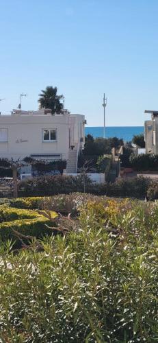 une maison blanche avec l'océan en arrière-plan dans l'établissement Marie Galante la plage au bout du chemin !, au Grau-du-Roi