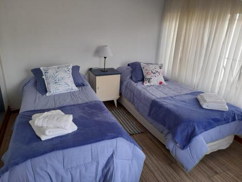 1 dormitorio con 2 camas y toallas. en Hortencia en El Bolsón
