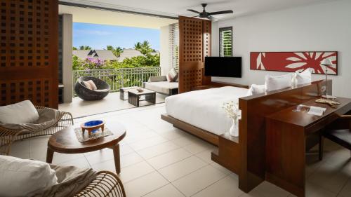 1 dormitorio con 1 cama y sala de estar con balcón. en InterContinental Fiji Golf Resort & Spa, an IHG Hotel, en Natadola