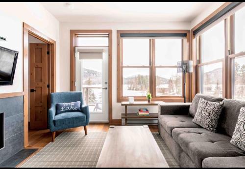 a living room with a couch and a chair at Suites sur Lac Superieur-Mont-Tremblant in Lac-Superieur