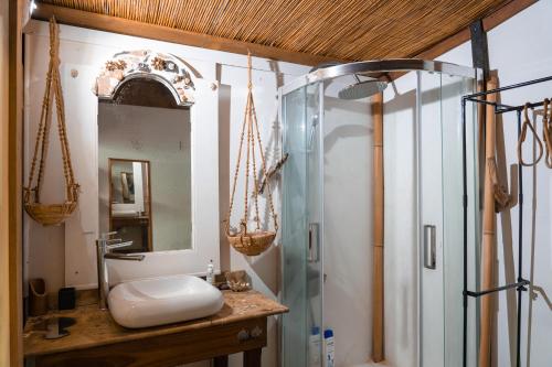 a bathroom with a glass shower and a sink at Le Charme Polynésien proximité plage et commerces in Punaauia
