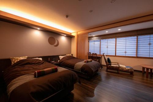 een hotelkamer met 2 bedden en een raam bij Wakamatsuya in Zao Onsen