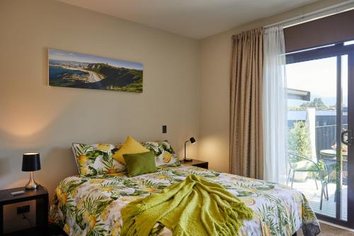 a bedroom with a bed and a large window at Golfer's Retreat in Kaikoura