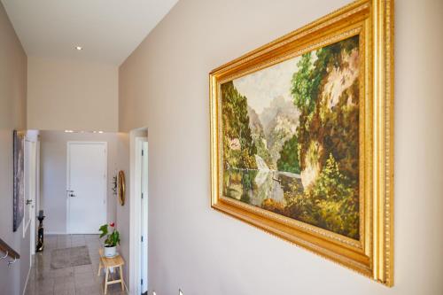 a painting hanging on a wall in a hallway at Golfer's Retreat in Kaikoura