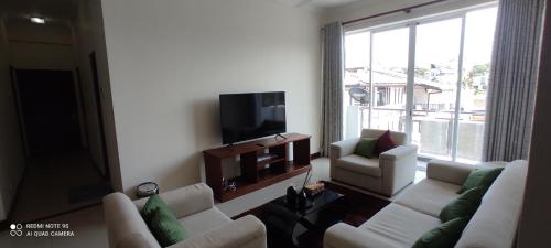 ein Wohnzimmer mit einem weißen Sofa und einem TV in der Unterkunft Asian Residencies @ Trillium, Colombo 7 in Colombo