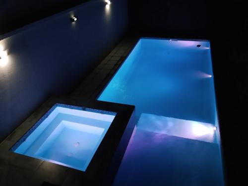 a large swimming pool with blue lights in a room at Doña Vanina in Villa Larca