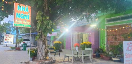 une table devant un bâtiment avec un arbre dans l'établissement Thuy Hang Motel, à Long Hải