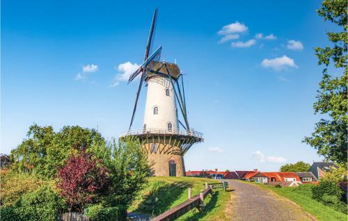 a windmill on a hill next to a road at 2 Bedroom Gorgeous Home In Ijzendijke in IJzendijke