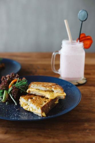 a blue plate with a sandwich and a salad on a table at BB Garden Resort in Canggu