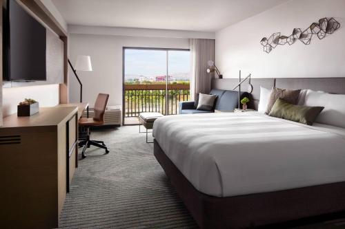 a hotel room with a large bed and a balcony at Santa Clara Marriott in Santa Clara