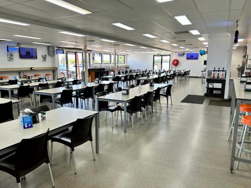een cafetaria met tafels en stoelen in een gebouw bij Leichhardt Accommodation in Moranbah