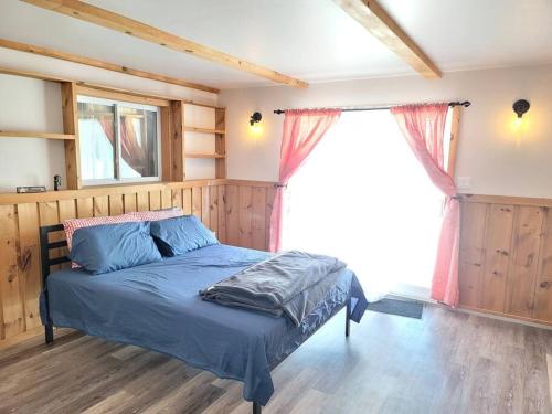 1 dormitorio con cama y ventana grande en Marshmallow home en Gilmour