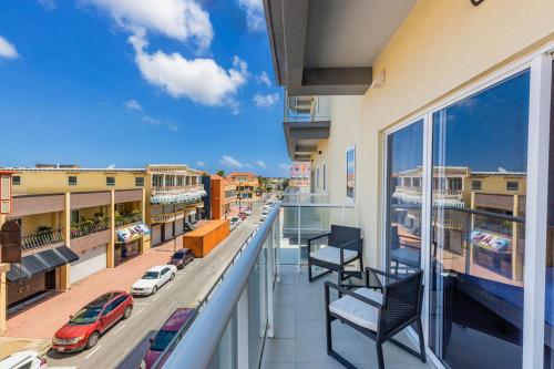 a balcony with a view of a city with cars at New Beautiful Aruban Studio Oceanfront in Oranjestad