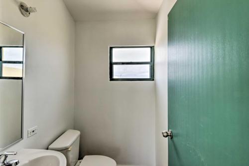 a bathroom with a toilet and a sink and a window at Steps to Beach Loiza Getaway with Rooftop Patio! in Loiza