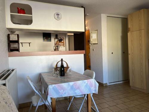 une cuisine avec une table et des chaises dans une pièce dans l'établissement Studio Cabine près Port et Plage, Calme, Commerces à 100m, Animaux Acceptés - FR-1-702-44, au Cap d'Agde