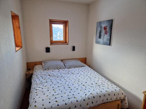 um pequeno quarto com uma cama e uma janela em Appartement Les Arcs 1800, 2 pièces, 4 personnes - FR-1-346-549 em Arc 1800