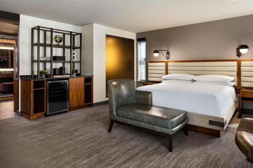 um quarto de hotel com uma cama e uma cadeira em Renaissance Minneapolis Hotel, The Depot em Minneapolis