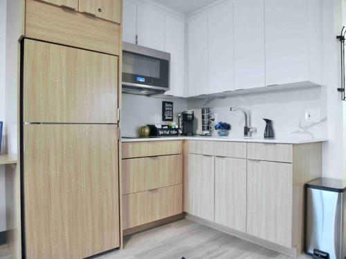 a kitchen with white cabinets and a refrigerator at Oslo Sapphire Flat in Murray