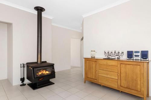 a kitchen with a wood stove in a room at Sandylands Busselton with WiFi in Vasse