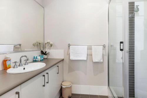 a white bathroom with a sink and a shower at Sandylands Busselton with WiFi in Vasse