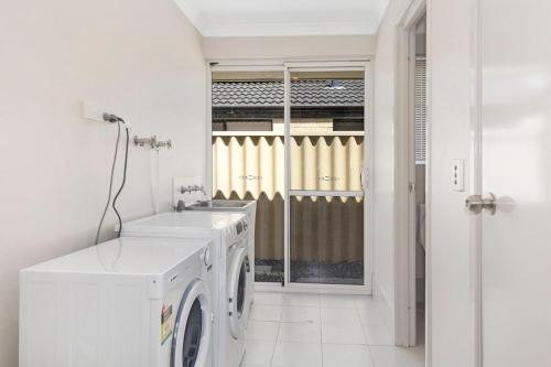 a white laundry room with a washer and dryer at Sandylands Busselton with WiFi in Vasse