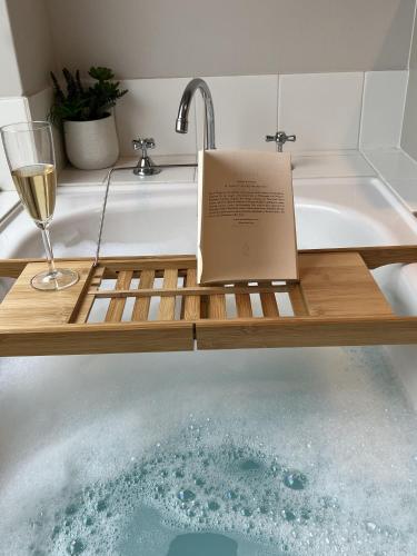 a book sitting on a wooden cutting board in a bath tub at Sandylands Busselton with WiFi in Vasse