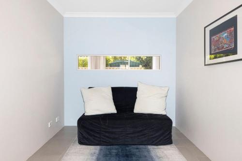 a room with a black couch in a white room at Sandylands Busselton with WiFi in Vasse