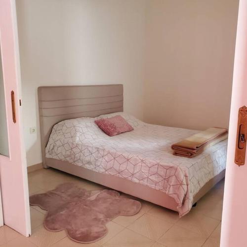 a small bedroom with a bed with pink sheets at HOME away from home_3BR at Maniatika_14min walk to the port in Piraeus