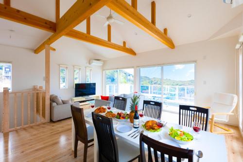 a dining room and living room with a table and chairs at ふくろう庵-白浜- in Shirahama