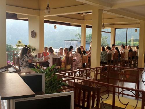 a group of people sitting at tables in a restaurant at Nature Walk Resort in Kandy