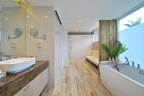 a bathroom with a white tub and a sink and a bath tub at Twin Lotus Resort and Spa - SHA Plus - Adult Only "November - April" in Ko Lanta