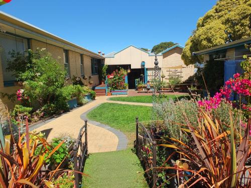 a garden with flowers and a walk way at 1849 Backpackers Albany in Albany