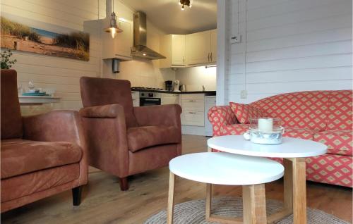 a living room with two chairs and a table at Nice Home In Heinkenszand With Sauna in Heinkensand