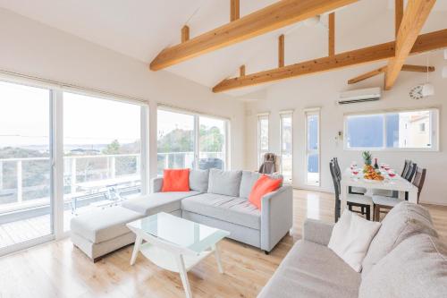 a living room with a couch and a table at ふくろう庵-白浜- in Shirahama