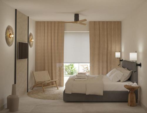 a bedroom with a bed and a chair and a window at Noa Suites in Arillas