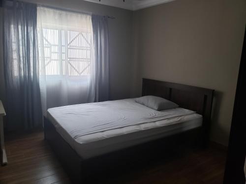 łóżko w sypialni z oknem w obiekcie Popsie's Paradise w mieście Jarbang