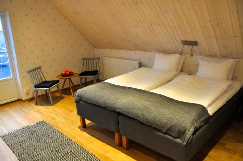 ein Schlafzimmer mit einem großen Bett im Dachgeschoss in der Unterkunft Nils Holgerssongården in Skurup