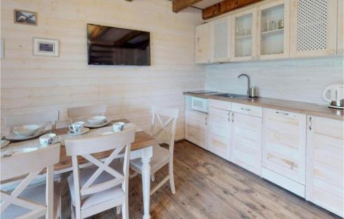 Una cocina con una mesa y sillas y un fregadero. en Lovely Home In Karwia, en Karwia