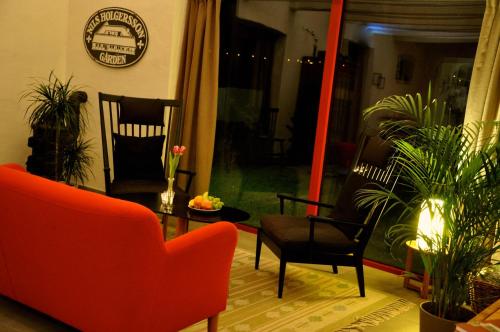 a living room with a red couch and chairs at Nils Holgerssongården in Skurup