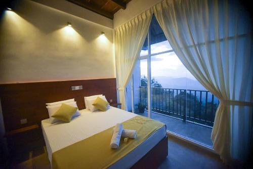 ein Schlafzimmer mit einem Bett und einem großen Fenster in der Unterkunft Tranquil Edge Villa in Haputale