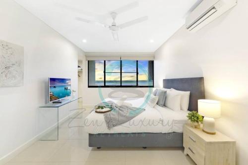 a white bedroom with a bed and a window at Zen Ocean Charm 3BR Luxury W/front Apt Pool + BBQ in Darwin