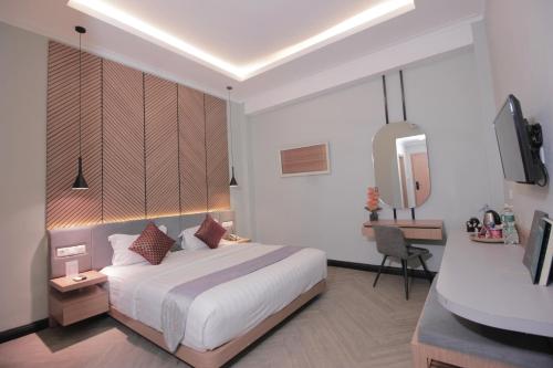 Muara Hotel Bukittinggi في Padangluar: غرفة الفندق بسرير ومغسلة