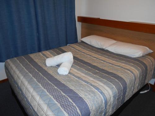 a bed with two rolled up towels on it at Grampians View Cottages and Units in Halls Gap