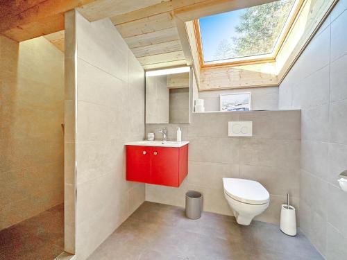 baño con lavabo rojo y aseo en Chalet Familial Les Girolles aux portes d'Anzère en Arbaz