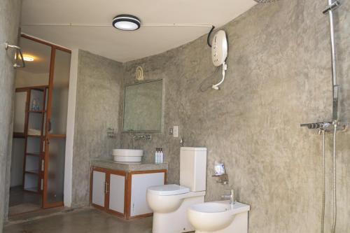 a bathroom with a toilet and a sink and a phone at The Blue Lagoon Resort Kalpitiya in Kalpitiya